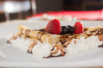 Fresh, golden pancakes with fruit and cream