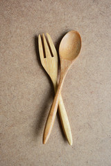 Wooden spoon and fork on wooden background.