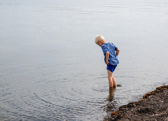 one little boy who are walking in the water