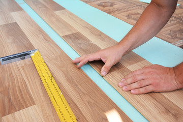 Man laying laminate flooring. Installing wooden laminate flooring. Step by Step.