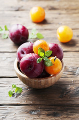 Sweet fresh black and yellow plums on the table