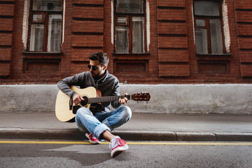 Man plays on guitar at the street