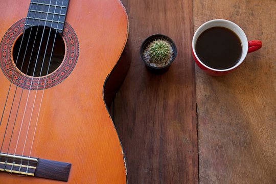 coffee cup and guitar on wooden table