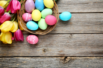 Easter eggs with tulips on a grey wooden table