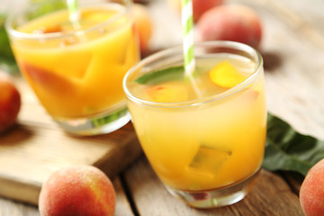 Glasses of peach juice on grey wooden table