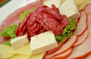     Sausage slices with lettuce leaf and white cheese
