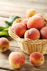 Sweet peach fruit in basket on grey wooden table
