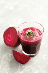 Fresh beets juice in glass on a grey background