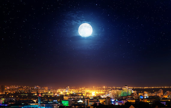 City landscape at nigh with moon. Elements of this image furnished by NASA.