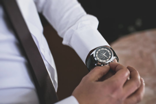businessman looking at his watch on his hand, watching the time
