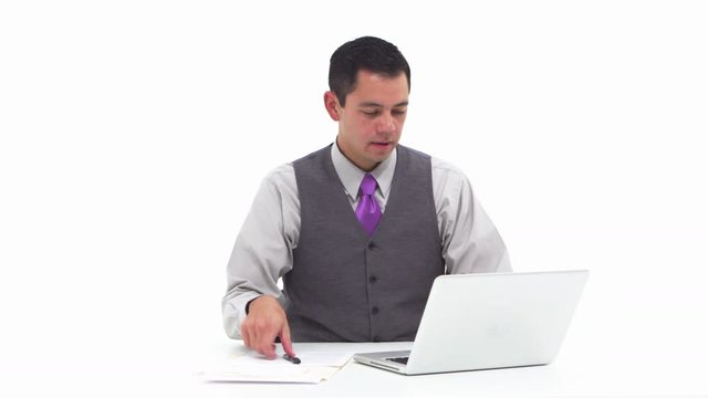 Businessman using laptop and taking notes