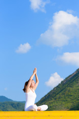 Young woman does yoga exercise outdoors.
