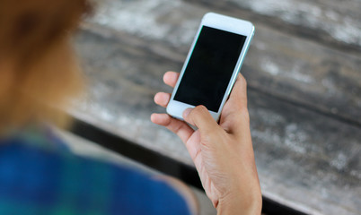 Woman use mobile phone in coffee shop from backside view.