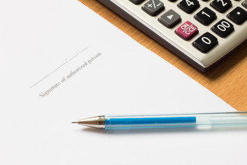 Pen, calculator on paper with Signature of authorized person wor