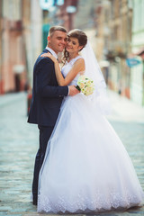 Naklejka premium Happy bride and groom dancing on a street
