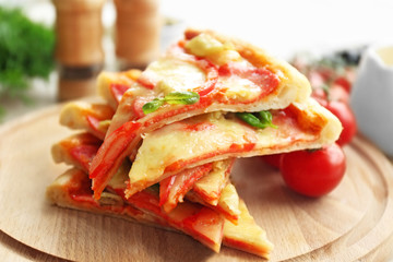 Delicious pizza slices on wooden cutting board