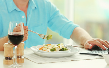 Man eating delicious pasta in restaurant