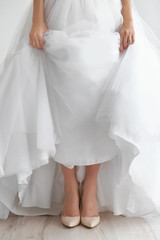 Fototapeta na wymiar Bride in a beautiful wedding gown and shoes