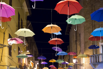 street in Ferrara with colorful umbrellas hanging in the air
