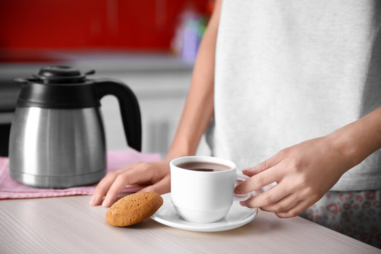 Woman pouring coffee in kitchen