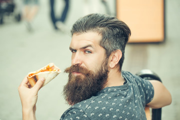 handsome bearded man eating pizza