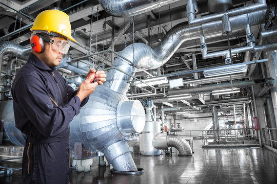Engineer working in a thermal power plant with talking on radio