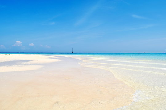 white sandy beach on a sunny day with blue sky.
