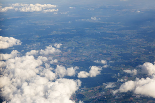 Fluffy clouds over the earth, the landscape. The scenic sky during sunset, the view from the air.
