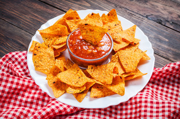 Nachos corn chips with spicy sauce on the table.