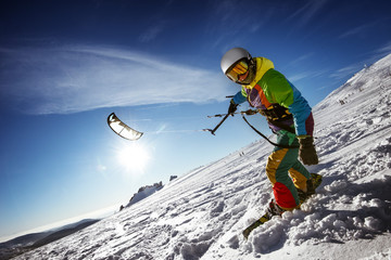 Happy snowboarder with snowkite stands in snowdrift