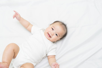 Portrait of a newborn Asian baby on the bed