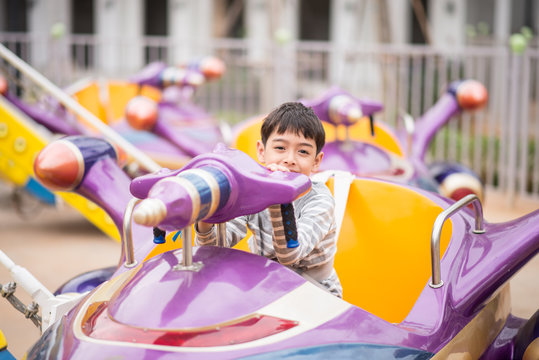 Little boy sitting in marry go round in amusement Theme park