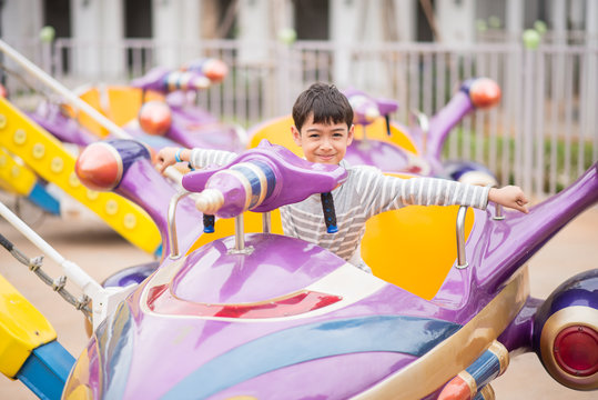 Little boy sitting in marry go round in amusement Theme park