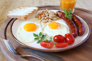 English breakfast with sausage, fried eggs and baked beans