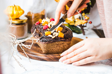 chocolate cake with pumpkin, nuts and frosting, to cut