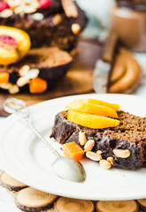 piece of chocolate cake with pumpkin, nuts and fresh peaches, se