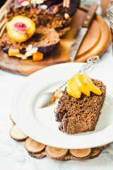 piece of chocolate cake with pumpkin, nuts and fresh peaches on