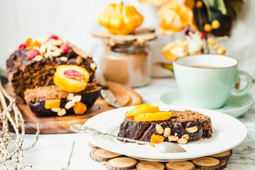 piece of chocolate cake with pumpkin, nuts and fresh peaches on
