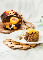 piece of chocolate cake with pumpkin, nuts and fresh peaches on