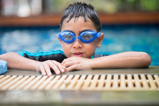 Little mix Asian Arab boy swimming at swimming pool in the hotel outdoor activity