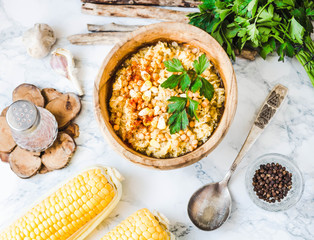 red lentil soup with corn, paprika and herbs in wooden plate