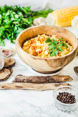 red lentil soup with corn, paprika and herbs in wooden plate