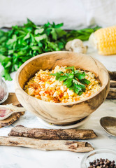 red lentil soup with corn, paprika and herbs in wooden plate