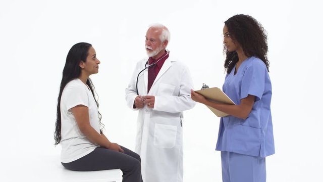 Senior doctor checking female patient with nurse