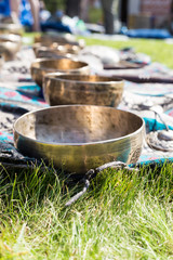 Singing bowls for massage in a row on grass