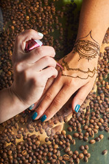 Master makes henna on a female hand. Mehendi and brown henna.