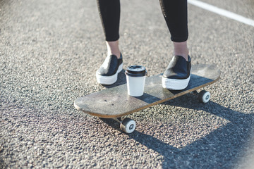 sunrise skateboarding woman legs and coffee on the board