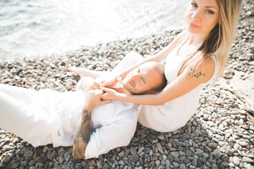 Just married wedding couple walking on the beach at sunset.