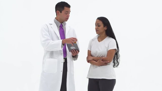 Doctor using tablet and giving female patient pills and medication
