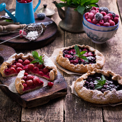 Blueberry,cherry,raspberry and blackcurrant galette on w wooden background.